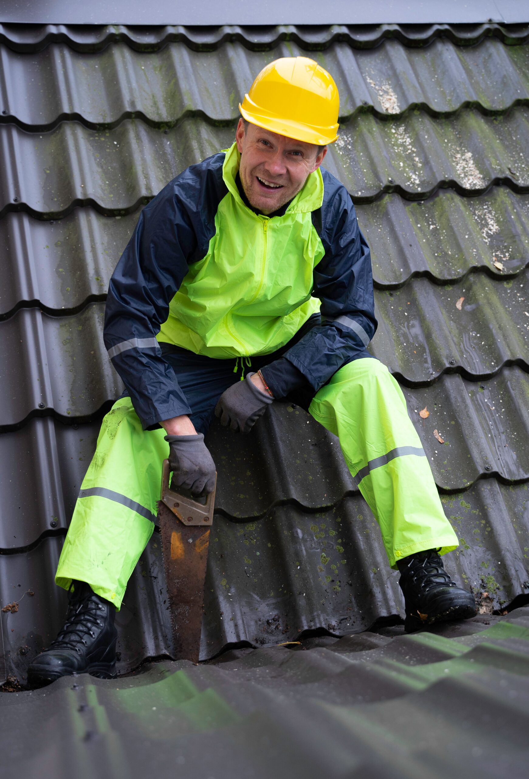 Smiling Dragon Roofing crew member working on a metal tile roof